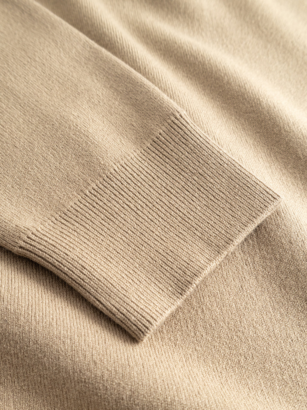 Close-up of the Gabba GABadriel Half Zip Lume LS Knit in Sand Crocker, featuring a detailed view of the ribbed cuff on the beige viscose blend sleeve against a matching knit background.