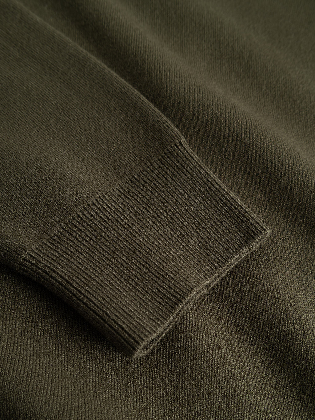 Close-up of the sleeve on the GABadriel Half Zip Lume LS Knit in Forest Night by Gabba, highlighting the ribbed cuff and soft, textured viscose blend knit fabric of this regular fit sweater.