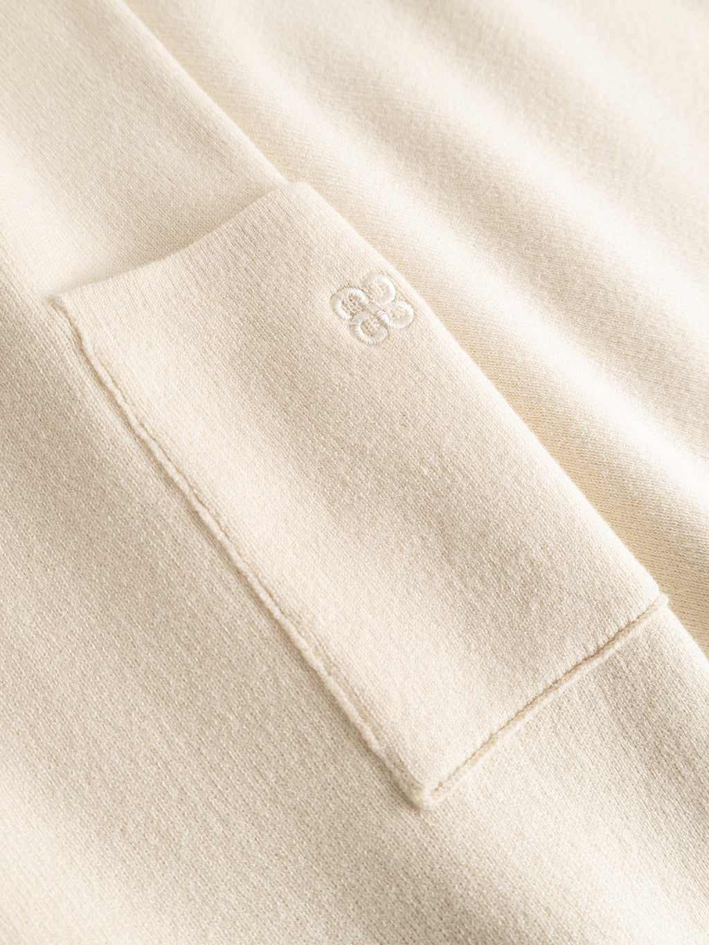 Close-up of the Gabba GABadriel O-Neck Lume LS Knit in Birch, showcasing its beige, soft-textured viscose blend fabric with a rectangular stitched pocket and a small embroidered logo above the pocket’s top edge.