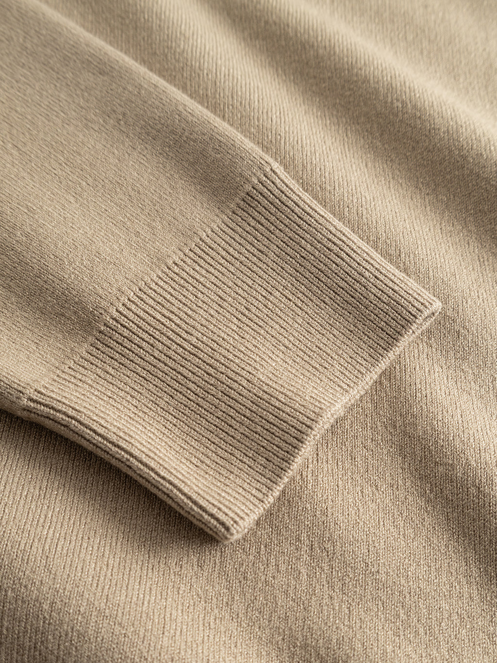 Close-up of the sleeve cuff of the Gabba GABadriel O-Neck Lume LS Knit in Sand Crocker, highlighting the fine ribbed texture and stitching detail on the viscose blend knit fabric against a matching background.