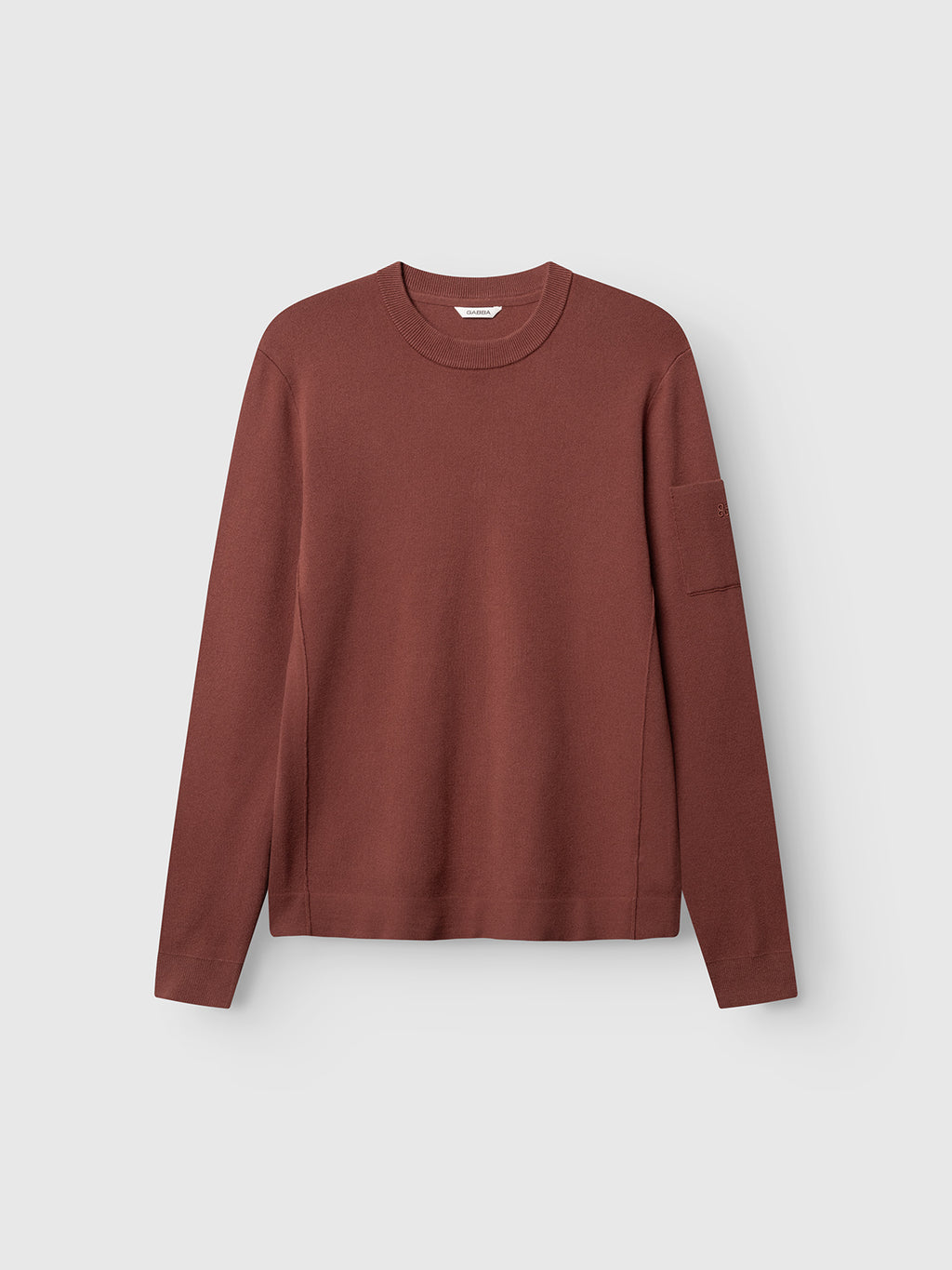 A long-sleeve, crew neck GABadriel O-Neck Lume LS Knit sweater by Gabba in brick red, featuring a minimalist design and a regular fit knit, shown against a plain light gray background.