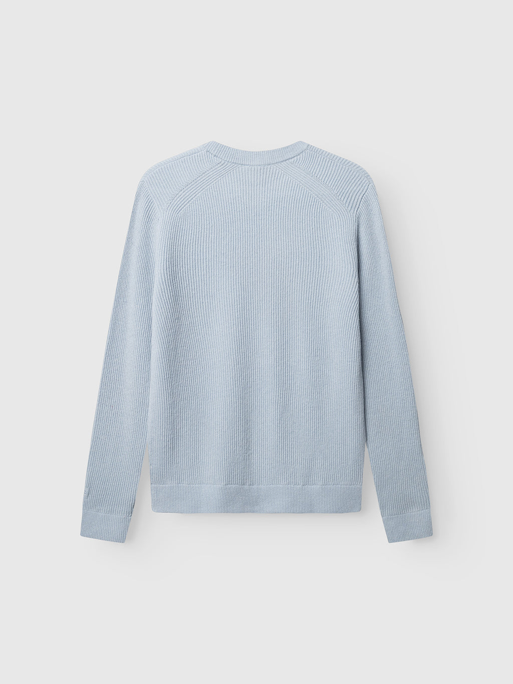 GABremy O-Neck Flash LS Knit by Gabba in Dusty Blue is shown flat with the back facing up, featuring long sleeves, a ribbed texture, and a classic crew neck. Made from 100% wool, it is set against a plain white background.