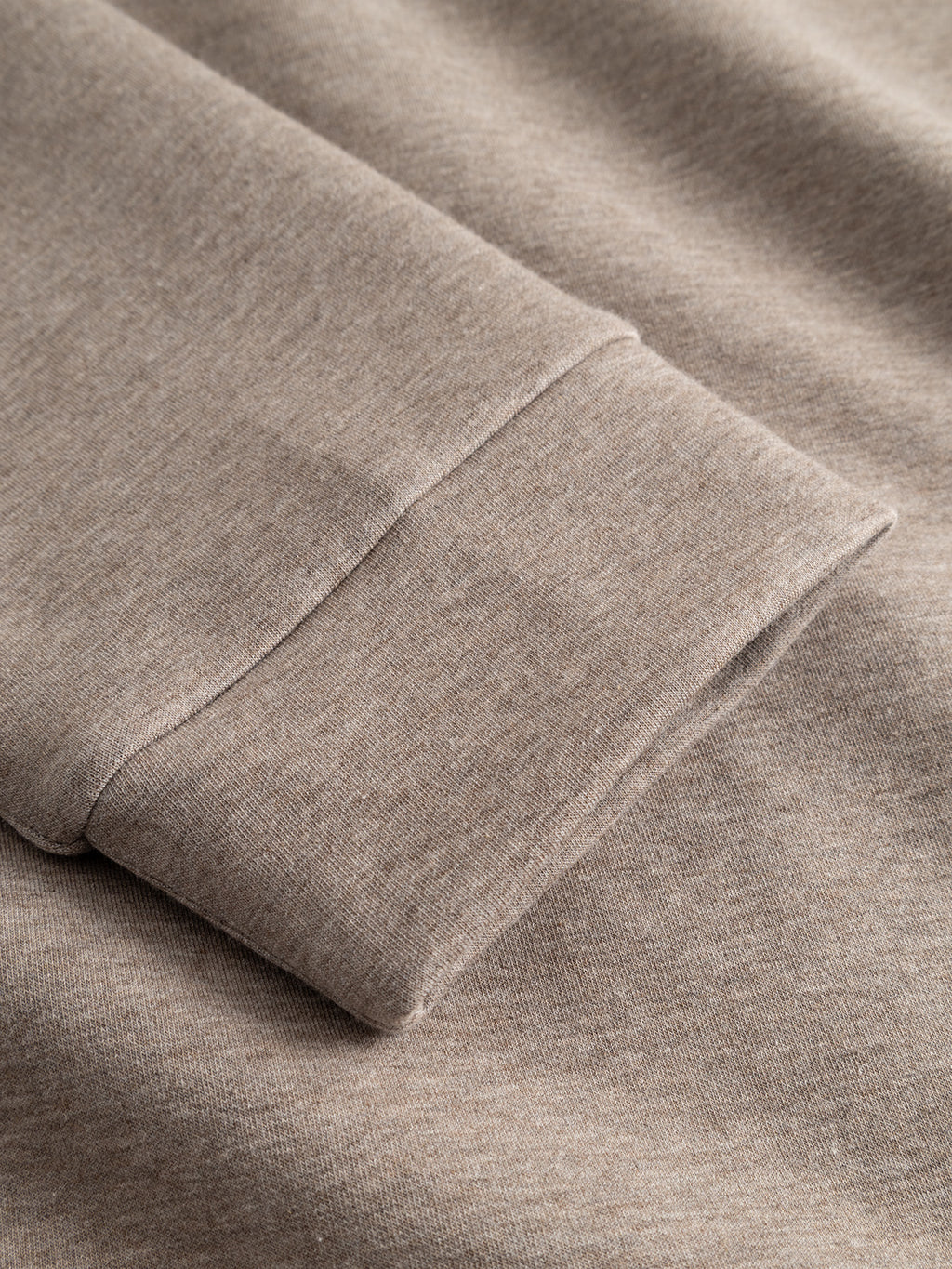 A close-up of the Gabba GABnik Camp Lock Sweat in Sand Mel reveals the texture and stitching detail of its mid-weight interlock fabric—an essential feature in modern outerwear.
