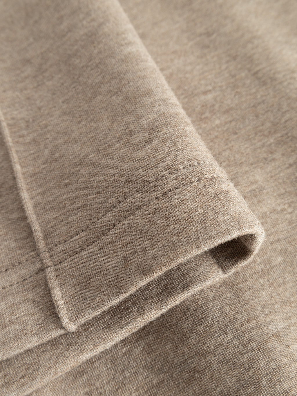 Close-up of the hem of the Gabba GABmonza Cropped Tasca Lock Pant in Sand Mel, highlighting neat stitching and the soft, smooth texture of its mid-weight interlock fabric.