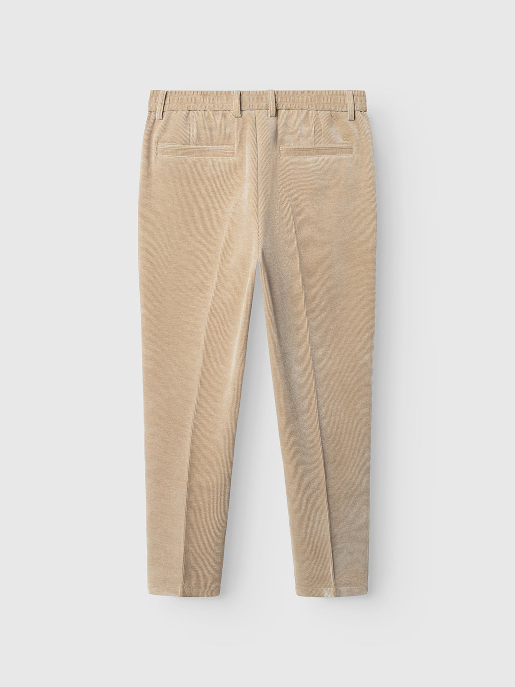The GABmonza Cropped Tasca Fune Pant - Sand Crocker by Gabba is shown from the back, highlighted in a beige corduroy jersey with a relaxed straight fit, two welt pockets, and an elastic waistband, set against a plain white background.