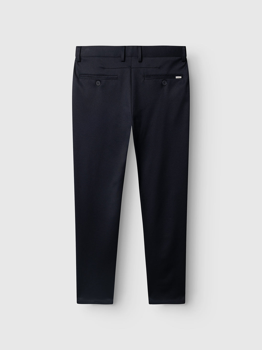 Back view of the Gabba GABpaul Dotty Pant in navy, featuring two buttoned back pockets, belt loops, and a small brand tag above the right pocket. Crafted from superstretch fabric for enhanced comfort and flexibility, displayed on a plain light gray background.