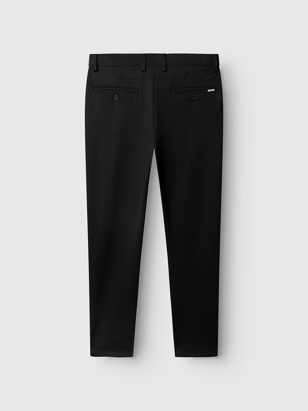 Back view of the Gabba GABpaul Dotty Pant in Meteorite, featuring a slim chino fit with two buttoned welt pockets and a small metal tag detail on the right pocket, crafted from superstretch fabric and displayed against a light gray background.
