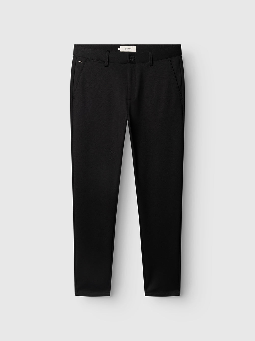 A pair of Gabba GABpaul Dotty Pant - Meteorite, featuring a black slim chino fit with belt loops and side pockets, crafted from superstretch fabric and displayed on a plain light gray background.