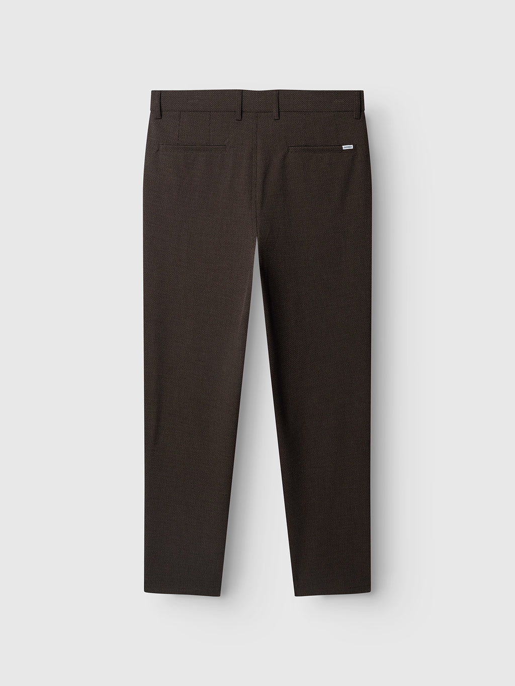 The GABjoe-pas Rubin Pant - Brown Slate by Gabba, crafted from textured dobby fabric in a dark brown hue, is laid flat on a plain light background and photographed from the back to display the two rear pockets and belt loops.