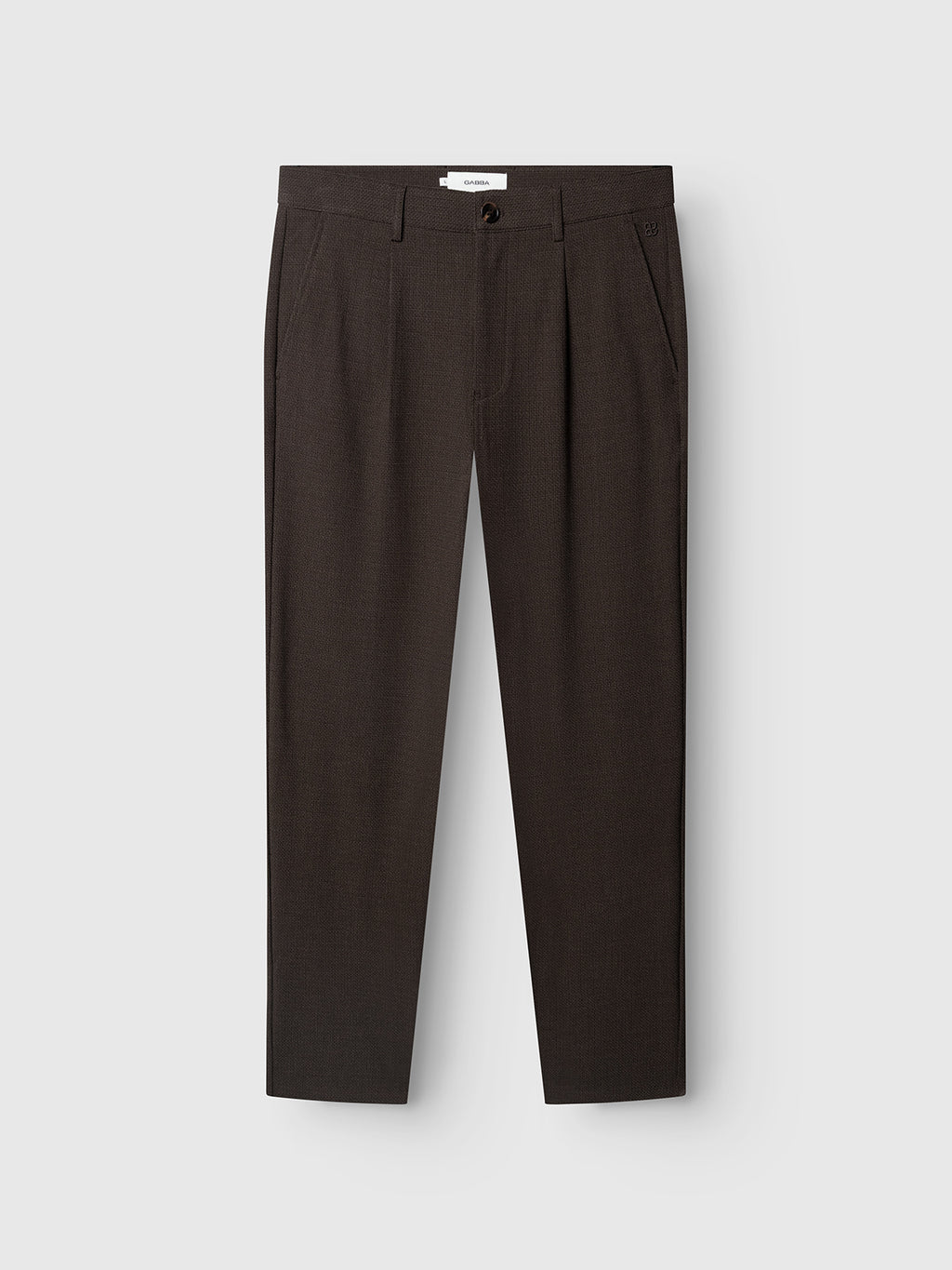 The GABjoe-pas Rubin Pant - Brown Slate from Gabba features a dark brown hue in a straight-leg tailored design, crafted from textured dobby fabric. These trousers include a button and zipper closure, waistband with belt loops, and side pockets, shown against a plain light background.