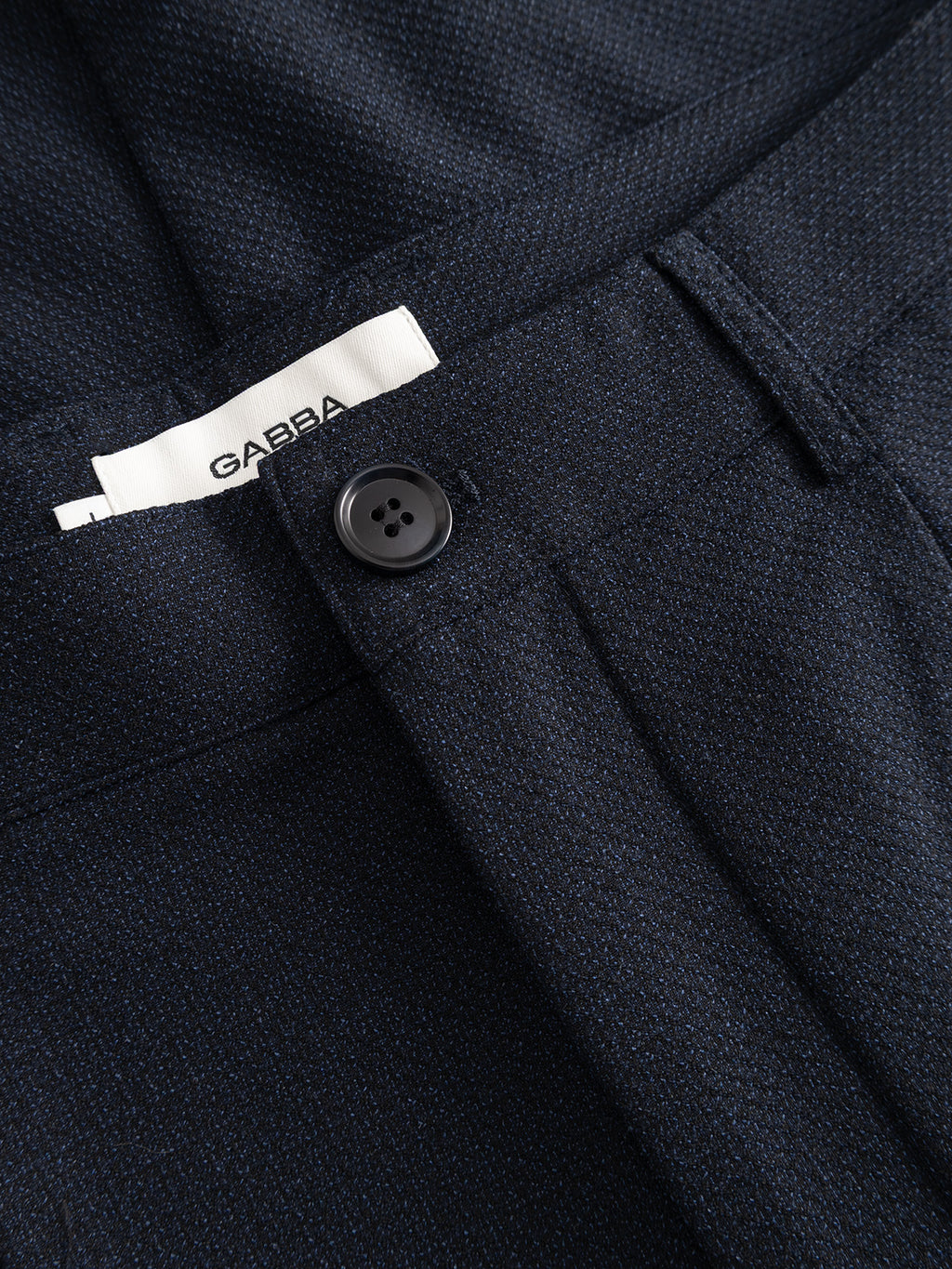 Close-up of Gabba GABjoe-pas Rubin Pant in Blue Black—a navy tapered fit pant featuring a black button and a visible white GABBA label near the waistband, crafted from stretch dobby fabric.