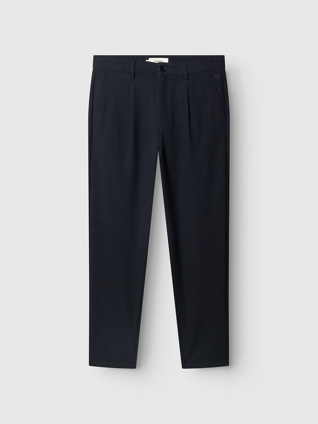 The GABjoe-pas Rubin Pant - Blue Black by Gabba is a pair of tailored trousers in a sophisticated blue-black shade, featuring front pleats and side pockets. Displayed flat against a light gray background, these tapered fit pants deliver a modern silhouette that’s both polished and versatile.