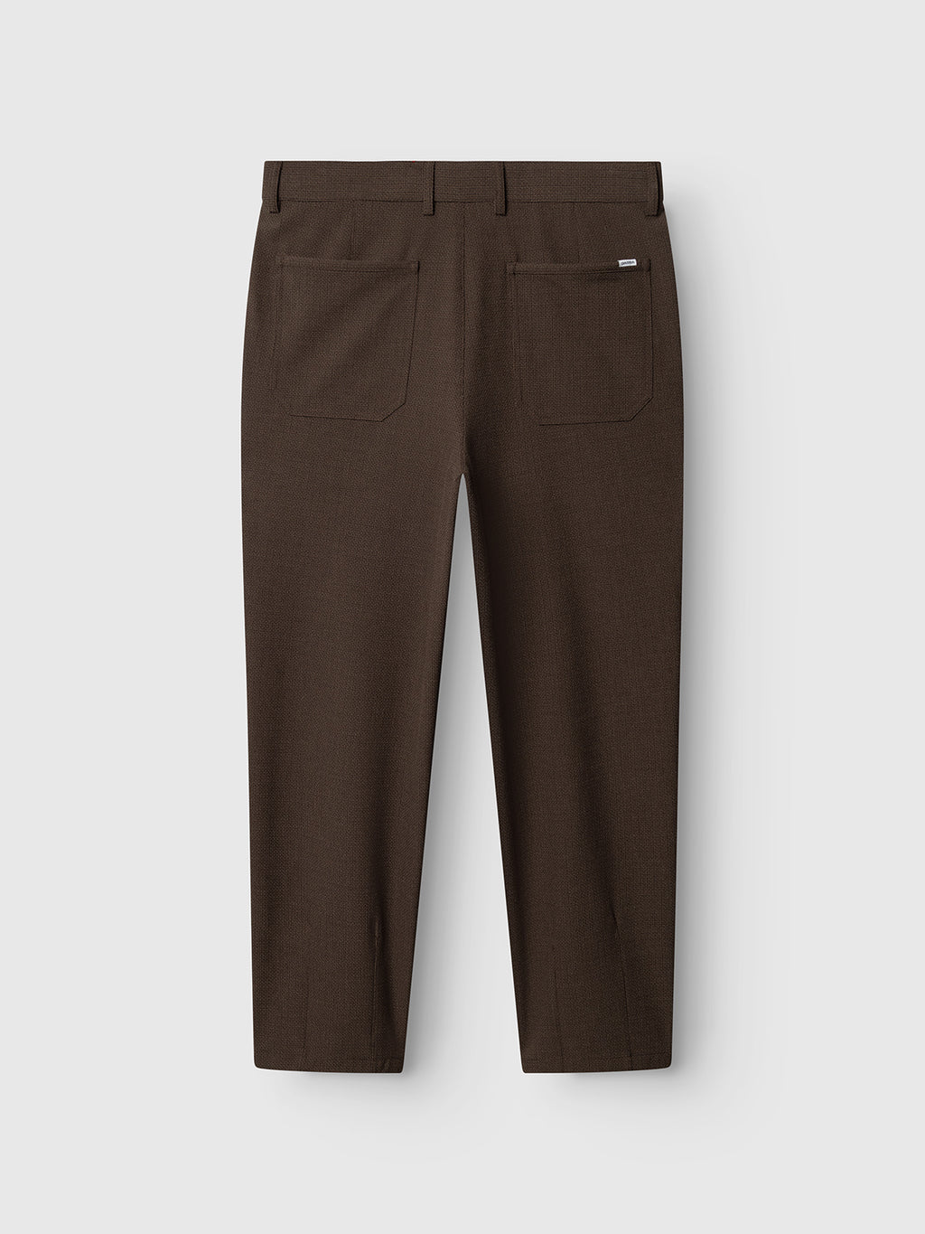 Back view of the Gabba GABdavid Rubin Pant in Brown Slate, featuring a loose tapered fit, two large rectangular back pockets, belt loops, and a small tag above the right pocket; crafted from stretch dobby fabric and shown against a plain light background.