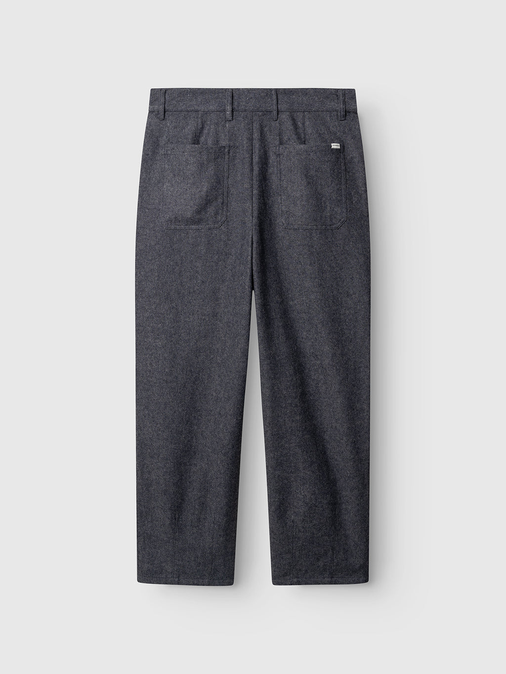 Navy GABdavid Twilight Pant by Gabba displayed flat, featuring the back side with two large rear pockets, belt loops, and a small rectangular brand tag on the upper-right pocket. Designed with a contemporary chino style and a loose tapered fit. The background is light gray.