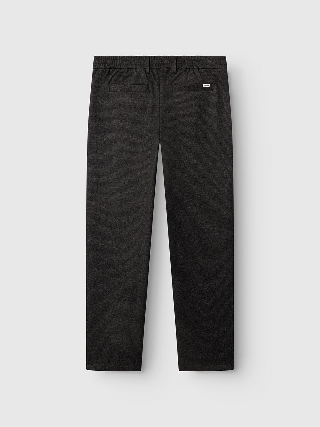 Back view of the Gabba GABnapoli 19 Zaffe GRS Pant in dark grey, featuring a regular straight fit silhouette crafted from soft stretch fabric. These trousers showcase an elastic waistband and two back pockets, one accented with a small label tag. Laid flat against a light gray background, they highlight their understated wool-look finish.