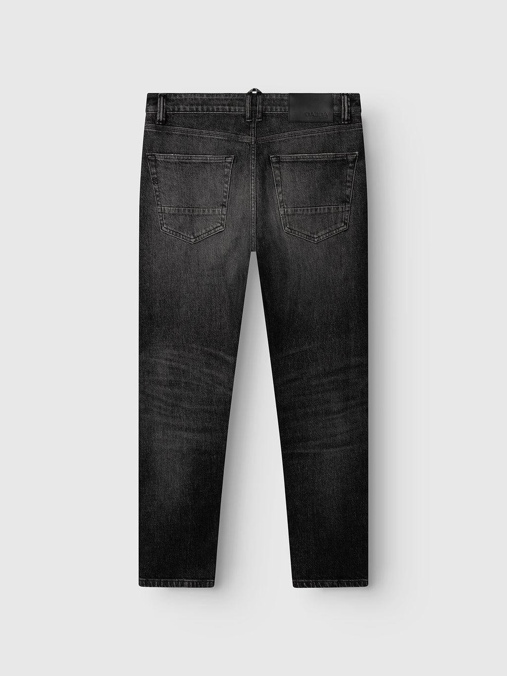 The Gabba GABcarl Blackrow DH0011 Jeans in black denim are displayed from the back, highlighting their washed black finish and subtle faded detailing along the legs. Designed with two back pockets and belt loops, these comfort stretch jeans are crafted from premium black denim and set against a plain light gray background.