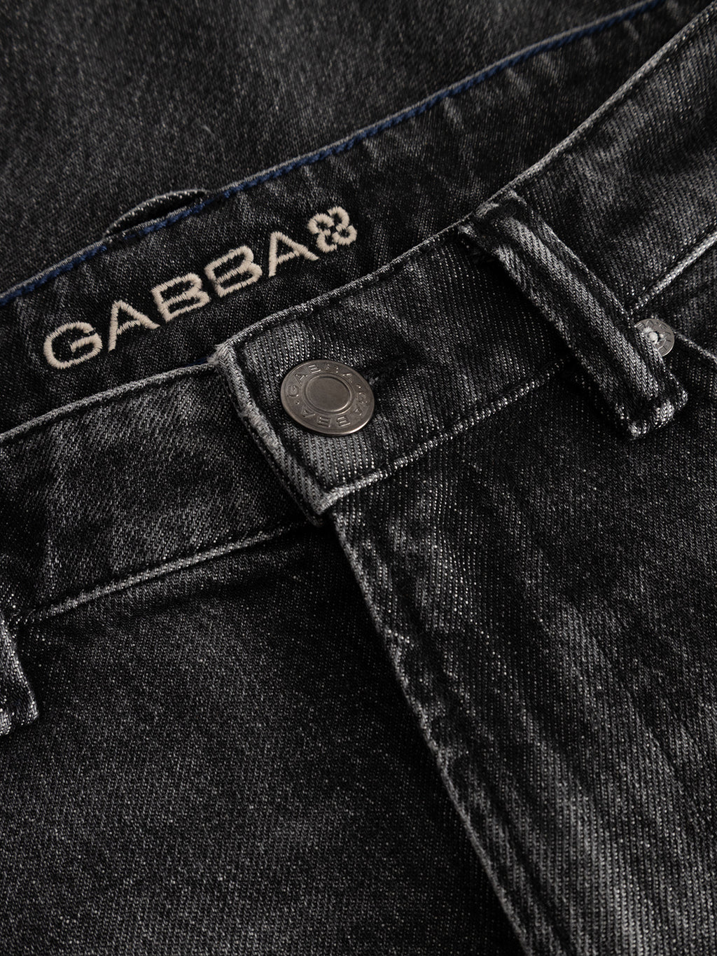 Close-up of the waistband of the GABcarl Blackrow DH0011 Jeans in black denim, showing a metallic button, belt loop, and the Gabba brand name stitched above the button.