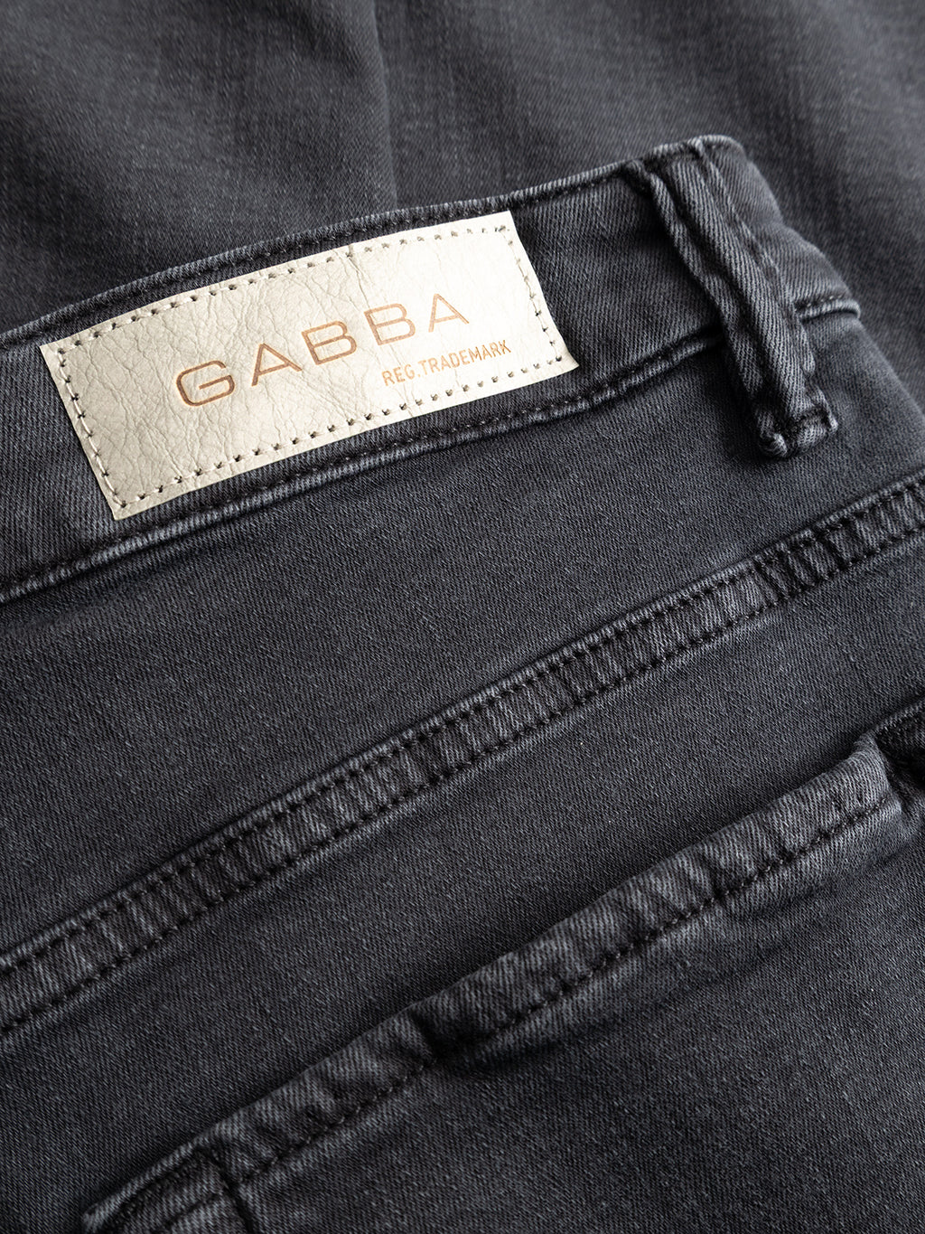Close-up of the GABjones Hesky Jeans in black denim by Gabba, featuring a beige fabric label with “GABBA REG. TRADEMARK” stitched above the back pocket.