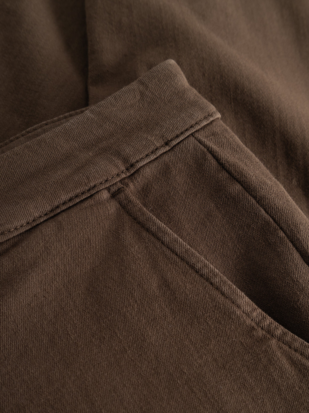 Close-up view of the Gabba GABpaul Hesky Pant in brown, showcasing the waistband and side pocket with detailed stitching and a soft fabric texture. These slim chino fit pants are crafted from high-stretch material, ensuring all-day comfort and flexibility.