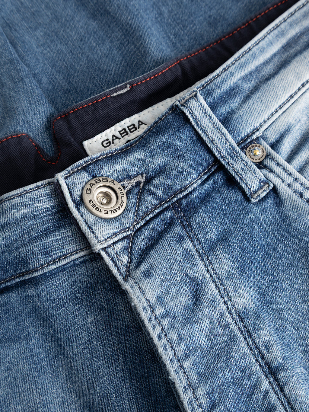 Close-up of the GABalex Cropped Nham RS2112 Jeans in mid blue denim, crafted from Gabba’s stretch denim, featuring a metal button, belt loop, fly, and a white label with the Gabba brand name stitched inside the waistband.
