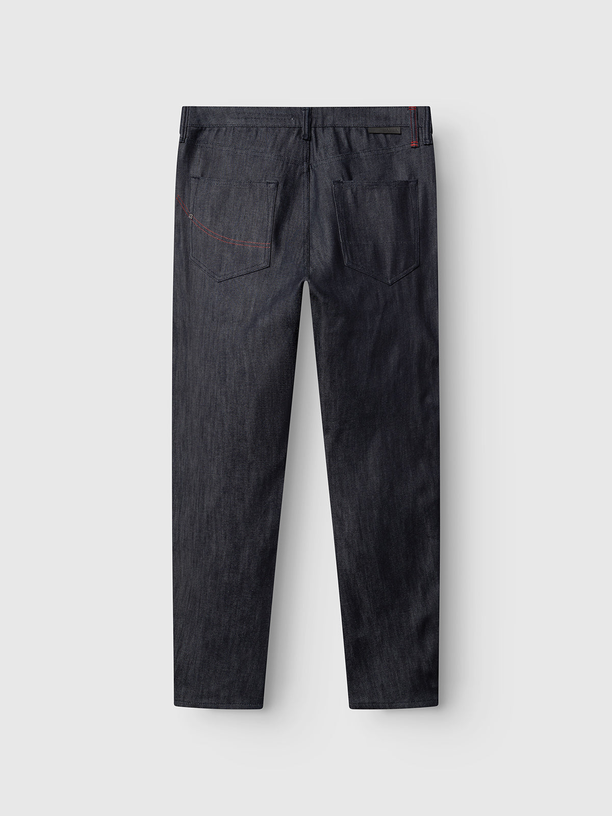 The GABcarl Anark Stone Raw Jeans by Gabba are shown from the back, crafted from premium ISKO denim in dark blue stone wash. Featuring two rear pockets with subtle red stitching on the right pocket, these jeans are displayed on a light gray background and offer a modern loose tapered fit.