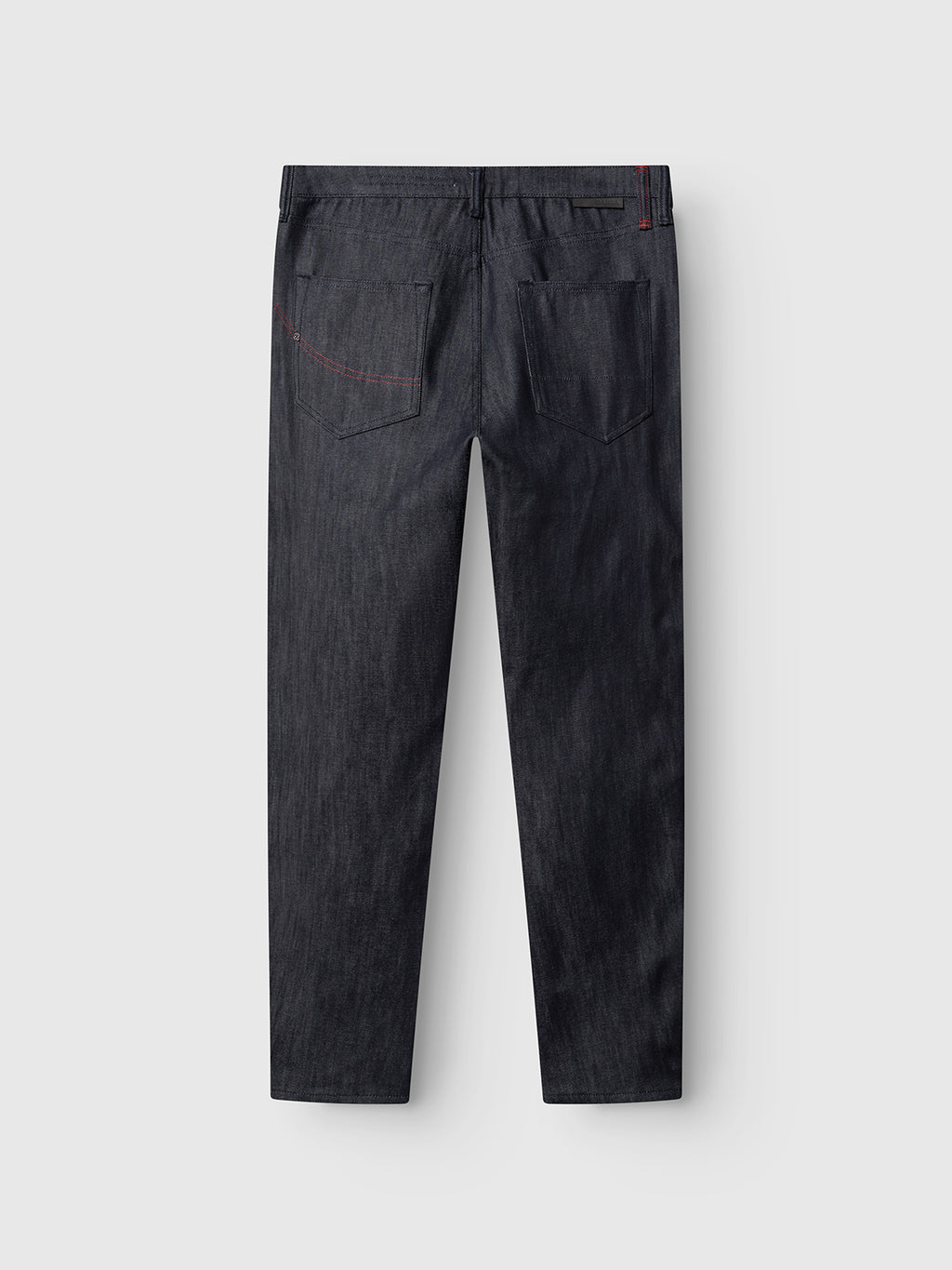 The GABcarl Anark Stone Raw Jeans by Gabba are shown from the back, crafted from premium ISKO denim in dark blue stone wash. Featuring two rear pockets with subtle red stitching on the right pocket, these jeans are displayed on a light gray background and offer a modern loose tapered fit.