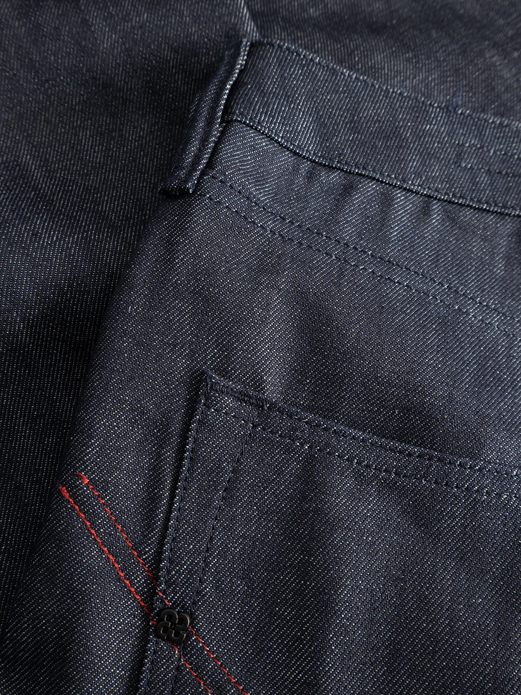 Close-up of GABcarl Anark Stone Raw Jeans in dark blue denim by Gabba, crafted from premium ISKO denim, highlighting the front pocket details, stitching, and a red accent near the edge.