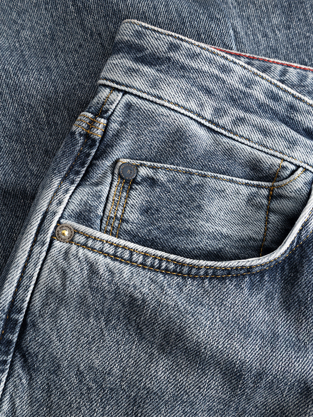 Close-up of the front pocket area of Gabba GABcarl Stone RS2103 Jeans in mid-blue denim, highlighting the coin pocket, stitching details, and a metal rivet on the premium stone-washed, faded fabric.