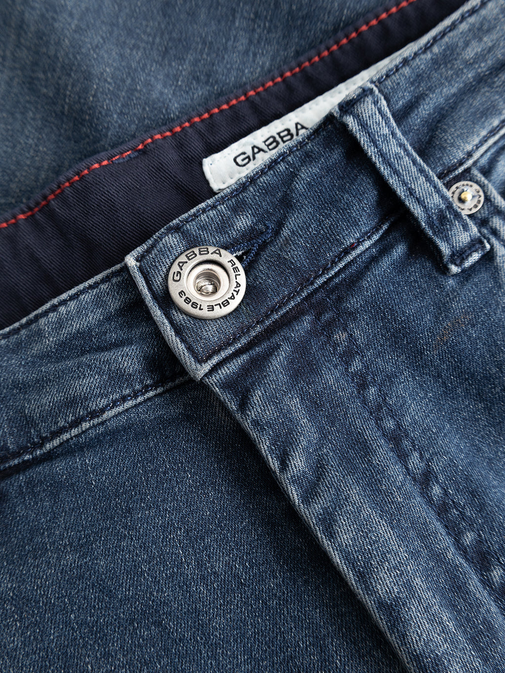 Close-up of the GABmarc Nham RS2113 Jeans in dark blue denim by Gabba, featuring a metal button engraved with “GABBA JEANS” and a white fabric label inside the waistband, also displaying the Gabba brand name.