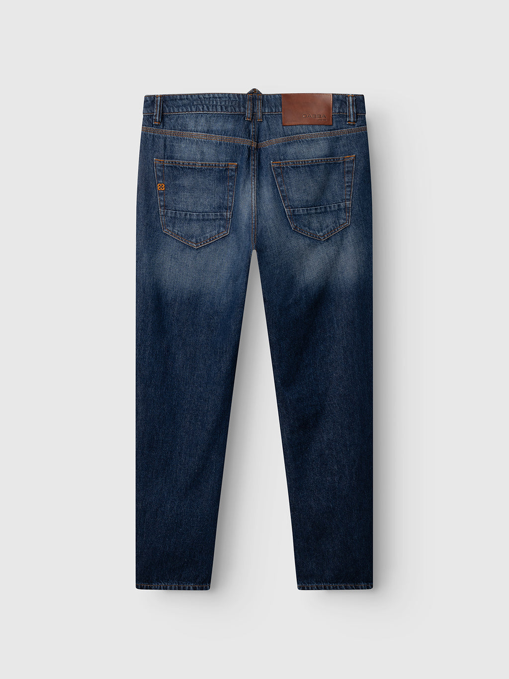 Back view of the Gabba GABcarl Tona RS2101 Jeans in mid blue denim, featuring two back pockets, subtle fading, a brown leather patch on the waistband, and straight legs, displayed on a light gray background.