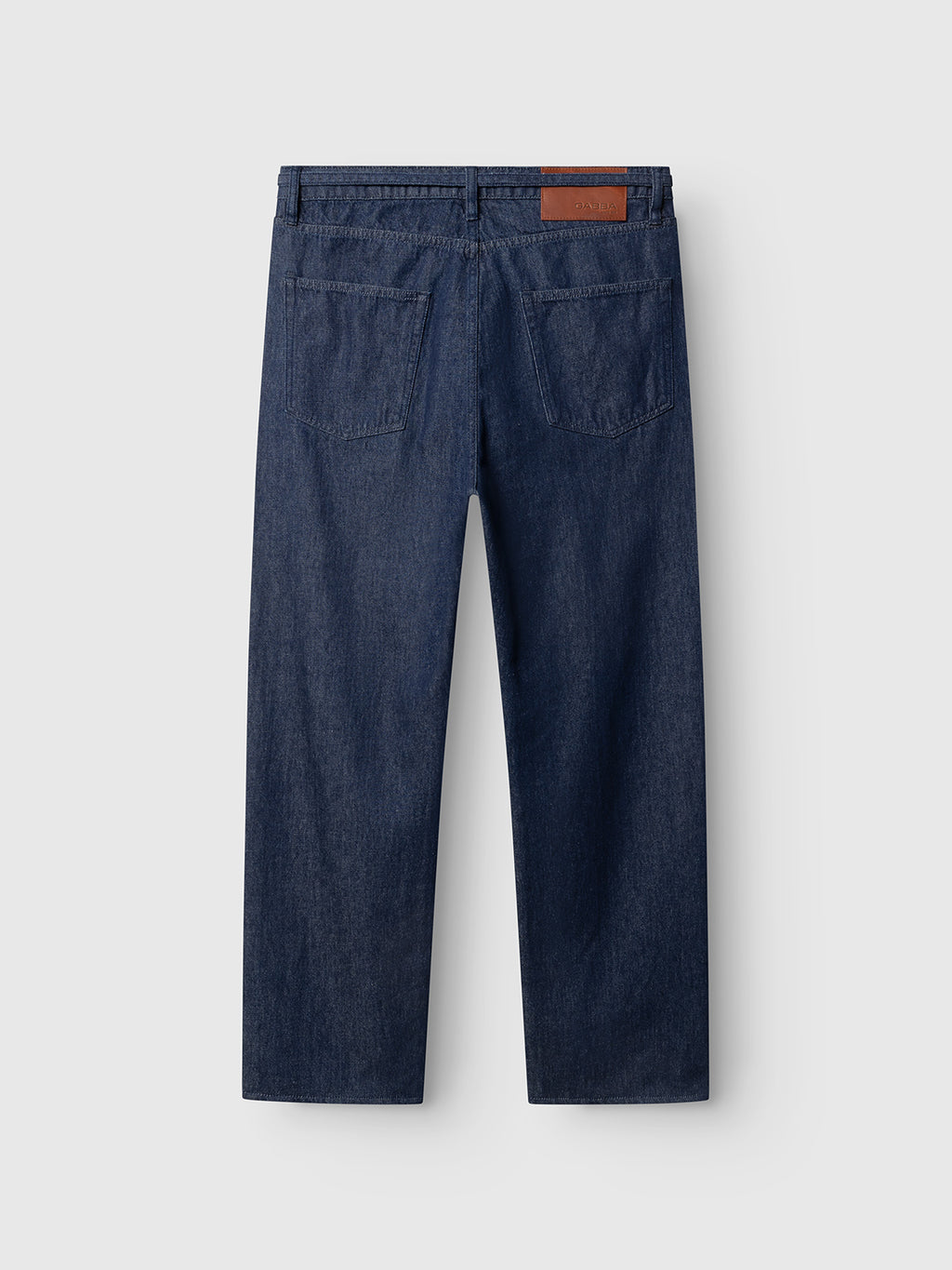 Back view of the Gabba GABnoah Tona Rinse Jeans in dark blue denim, crafted from a rigid indigo organic cotton blend. Featuring two rear pockets, belt loops, and a brown leather patch on the waistband, these loose straight fit jeans offer both comfort and timeless appeal. Displayed against a plain light gray background.