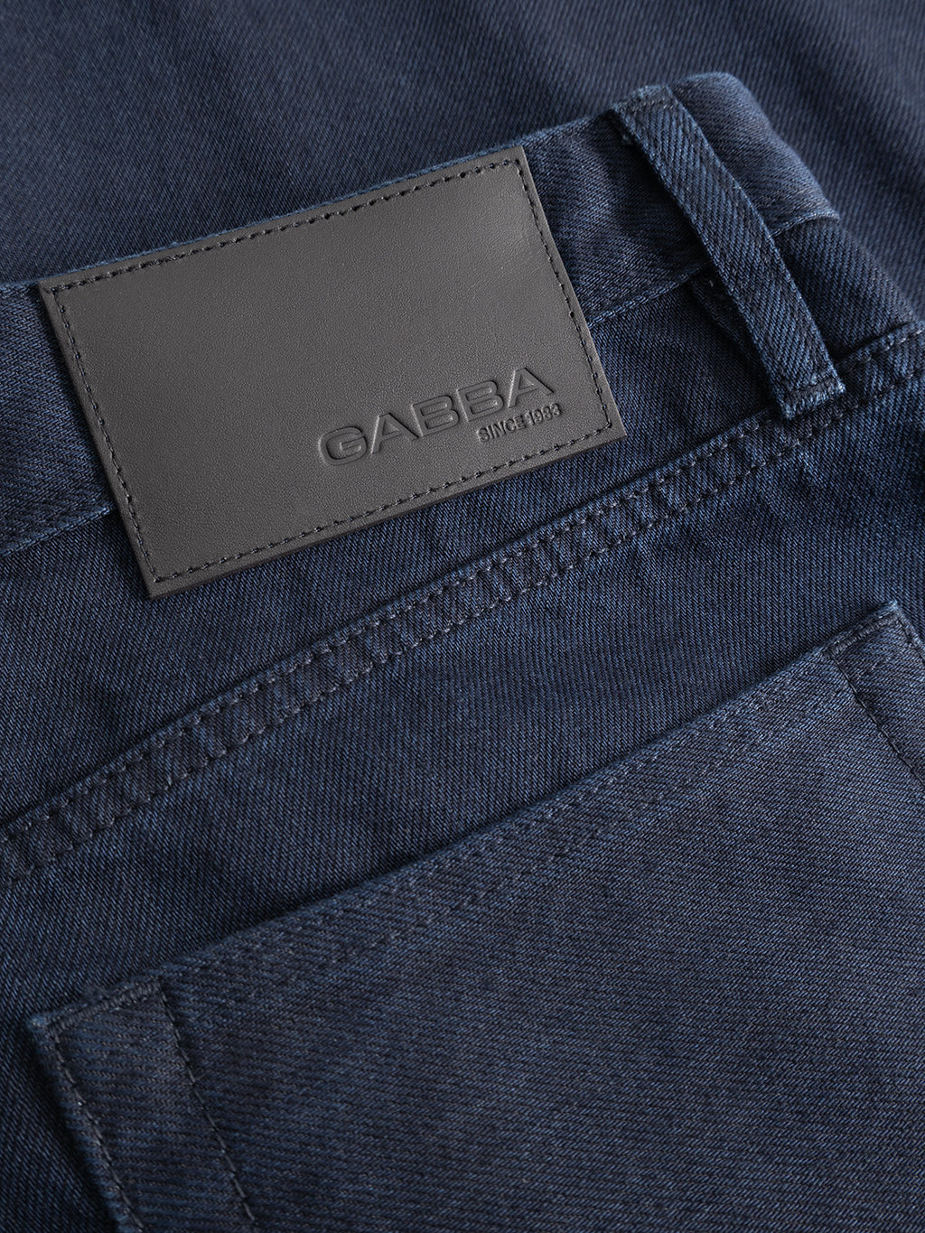 Close-up of a pair of GABsenna Denia Rinse Jeans in dark blue denim from Gabba, designed in a loose tapered fit and featuring a gray leather patch with the brand name “Gabba Since 1983” above the back pocket.