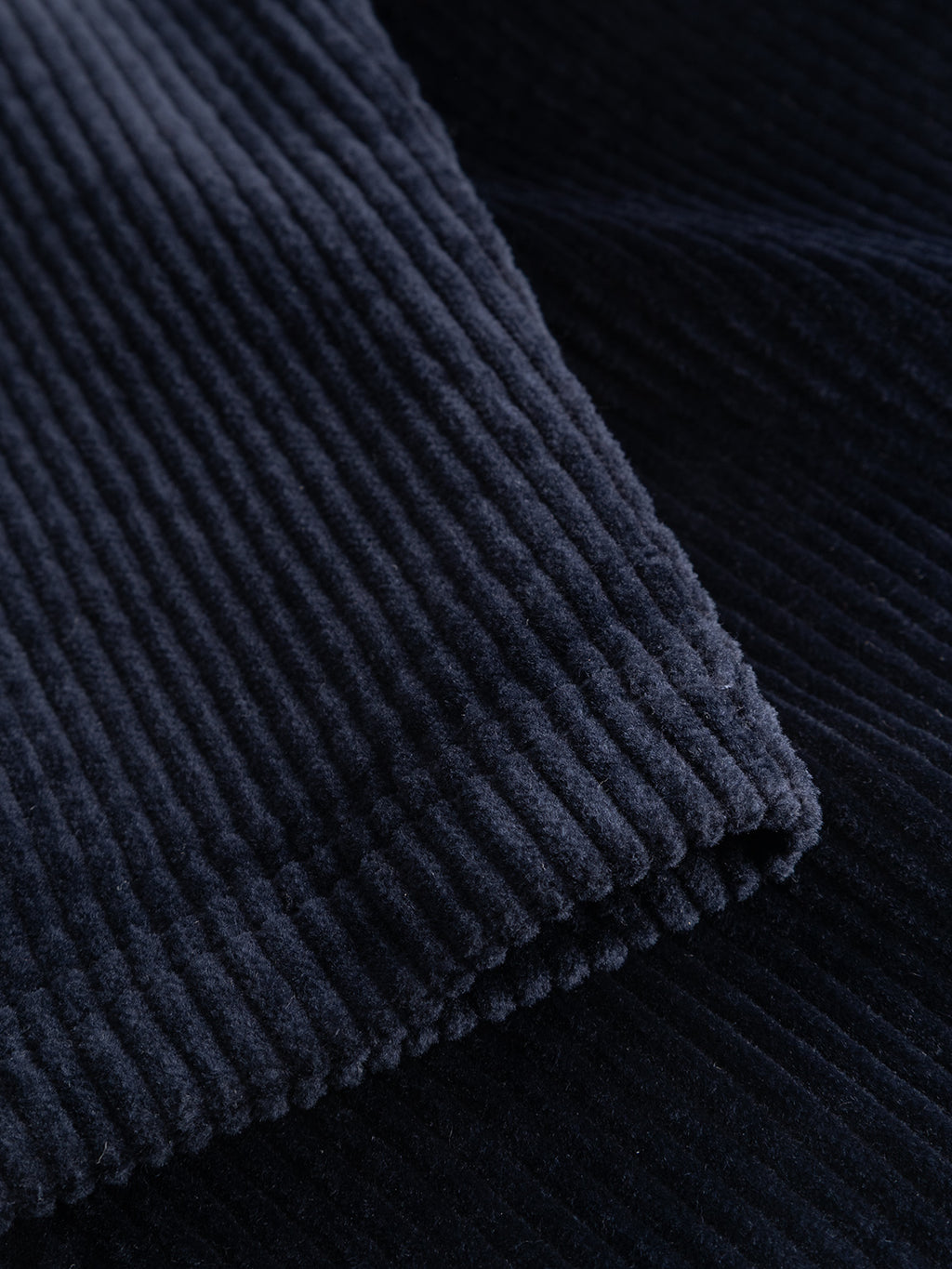 Close-up of the GABjoe Nopleats Ibre Pant in Dark Navy by Gabba, highlighting its stretch corduroy fabric with a distinctive vertical ribbed texture and soft, velvety surface.