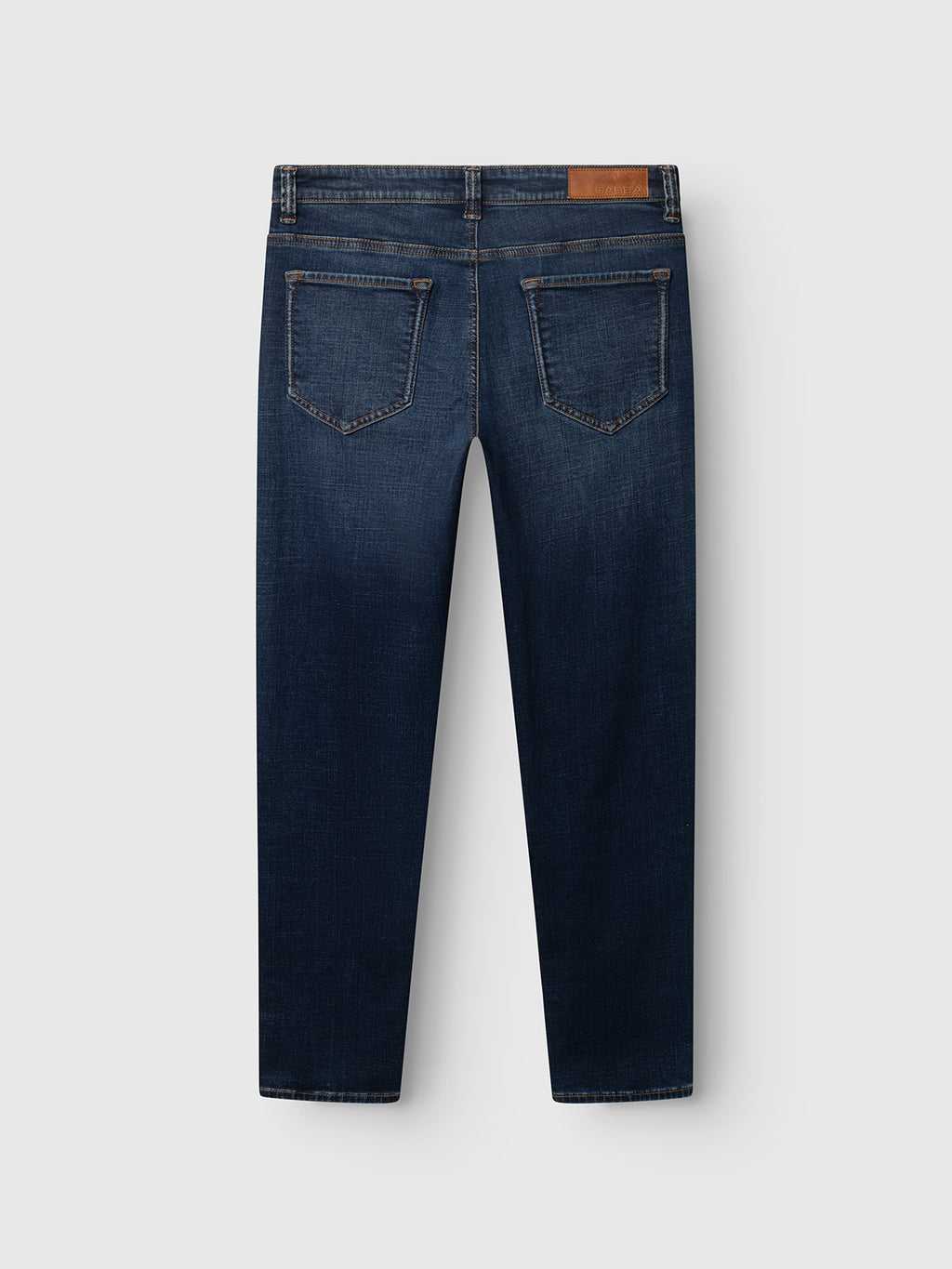 A pair of Gabba GABjones Bekham DS0002 Jeans in dark blue denim, shown from the back, featuring a slim straight fit in comfort stretch fabric, two rear pockets, brown stitching, and a tan leather patch on the waistband.