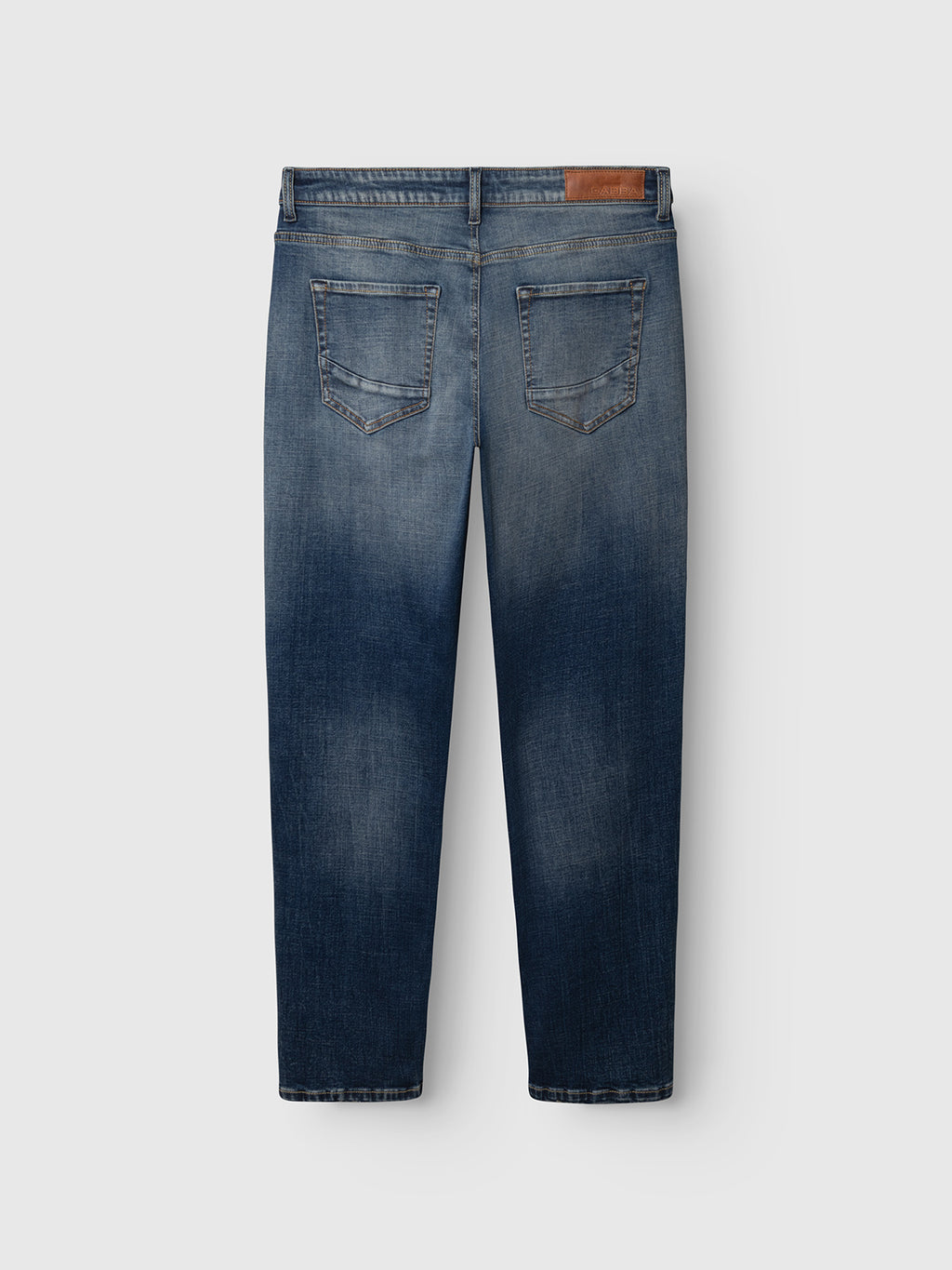 The GABmarc Bekham DS0003 Jeans by Gabba are shown from the back in a mid-blue denim wash, featuring two rear pockets, faded detailing, and a brown leather patch on the waistband. Crafted from comfort stretch denim with a regular fit, these jeans are designed for everyday ease.