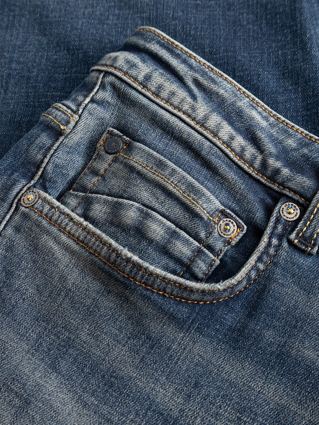 Close-up of the front and coin pockets of the Gabba GABmarc Bekham DS0003 Jeans in mid-blue denim, featuring visible stitching and metal rivets, crafted from comfort stretch denim for a regular fit.