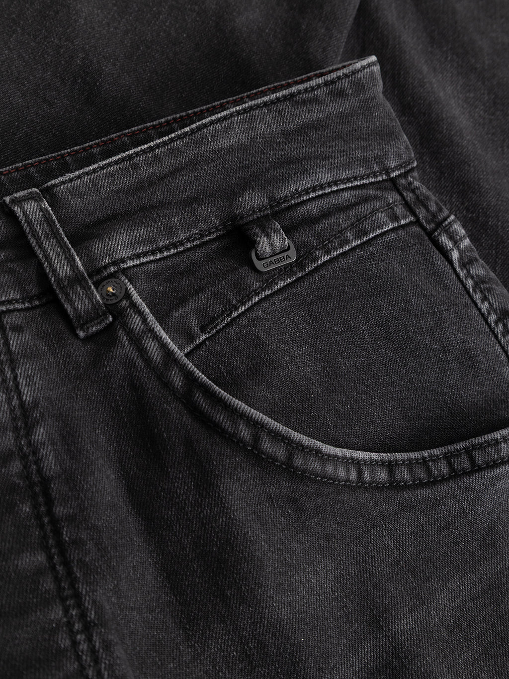 A close-up of the Gabba GABalex Cropped Blerb WW0031 Jeans in black denim shows the front pocket with prominent stitching and a small black tag above the pocket, crafted from high-density black denim with a washed black finish.