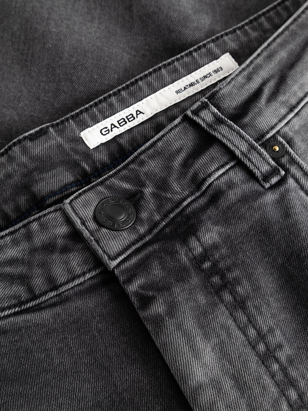 Close-up of Gabba GABmarc Blerb WW0032 Jeans in grey comfort stretch denim, featuring a black button and a white waistband label reading “GABBA RELIABLE FIT SINCE 1983.”.