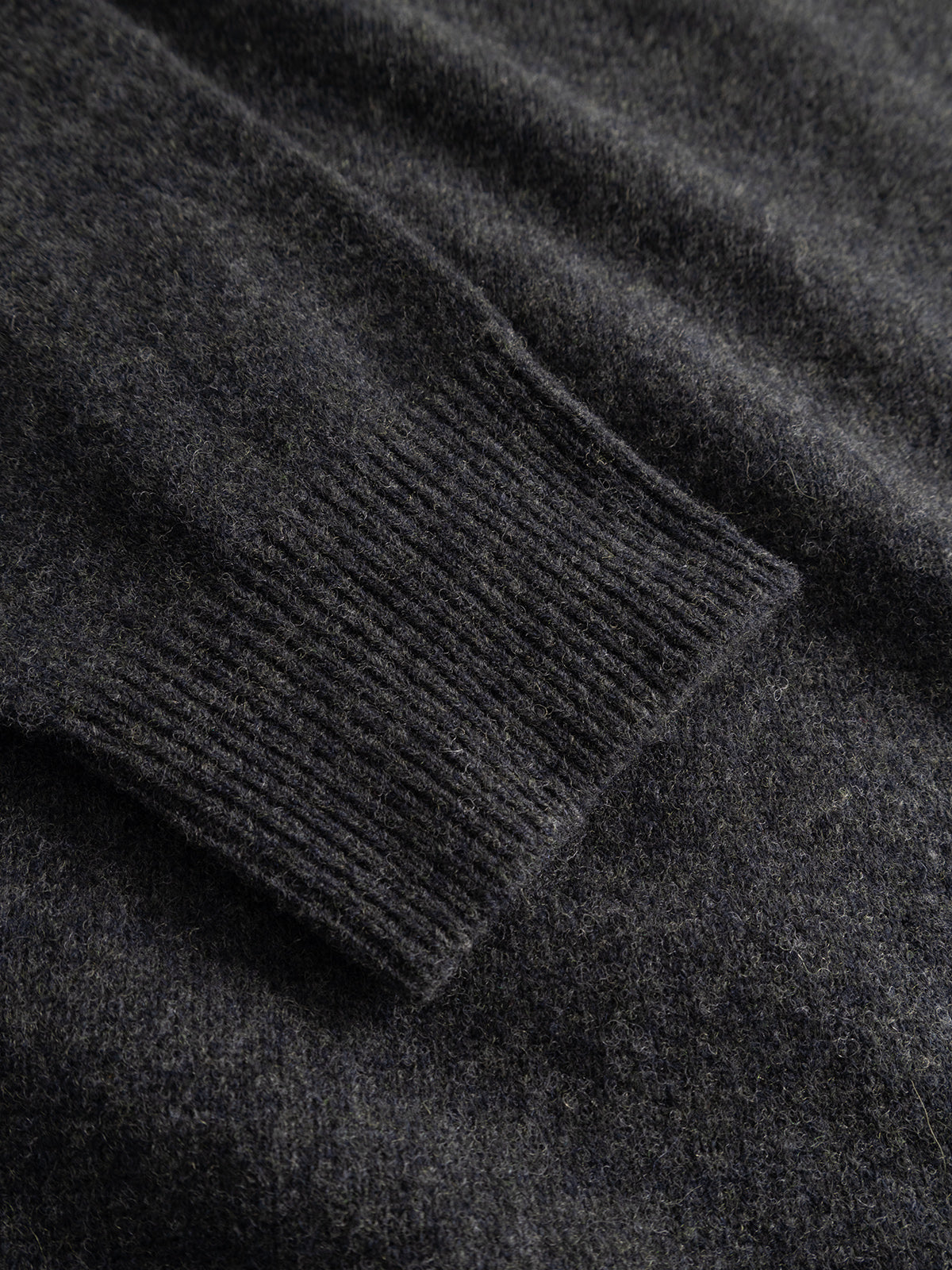 Close-up of the GABworren Polo Aico LS Knit sweater by Gabba in Dark Grey Mel, highlighting the ribbed cuff and soft, textured fabric of this men’s regular fit sweater.