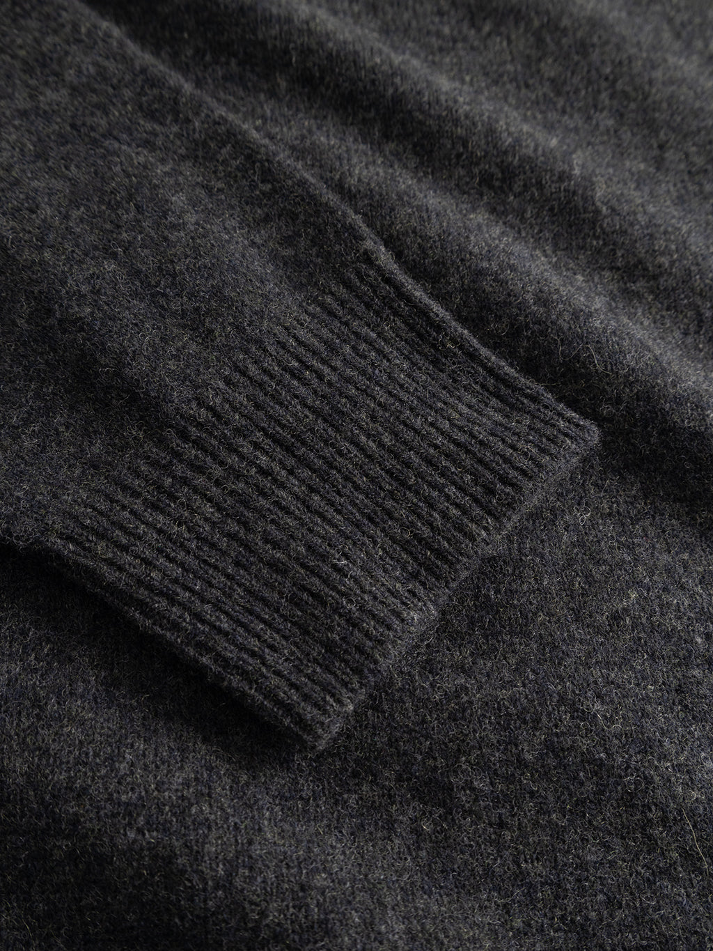 Close-up of the GABworren Polo Aico LS Knit sweater by Gabba in Dark Grey Mel, highlighting the ribbed cuff and soft, textured fabric of this men’s regular fit sweater.