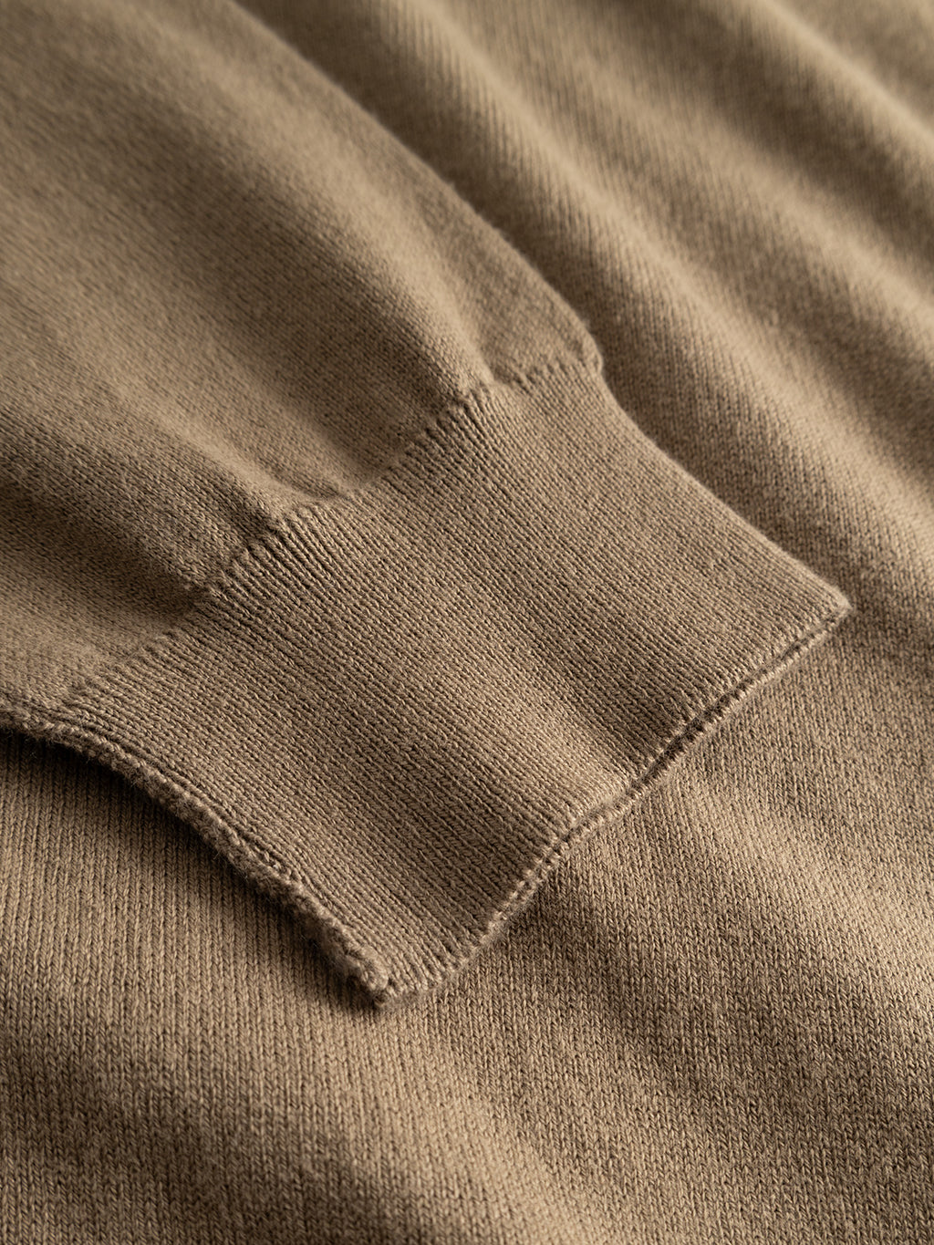 Close-up of the cuff of the GABfumo Element Spy LS Knit - Sand Crocker sweater by Gabba, featuring detailed stitching and fabric texture. The image highlights the ribbed cuff, smooth sand-colored material, and classic crew neck—a signature style from Gabba.