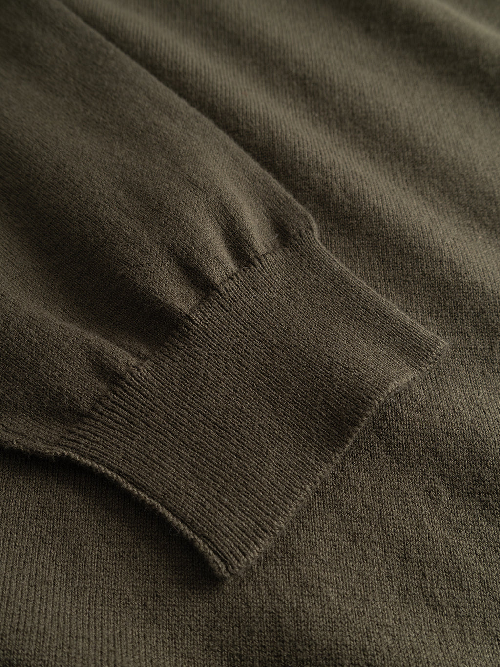 A close-up view of the cuff on the Gabba GABfumo Element Spy LS Knit in Forest Night highlights the fine ribbing and texture of its flat-knit cotton fabric—an ideal complement to this sweater’s classic crew neck and regular fit design.