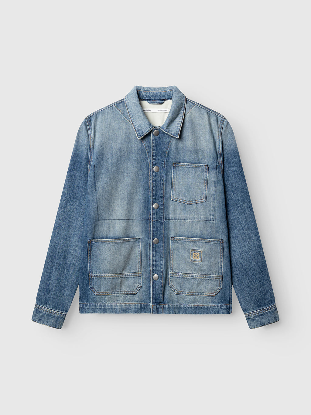 The Gabba GABbeta Wolv DS0004 LS Overshirt is a dark blue denim layer featuring a collar, metal buttons, and three spacious front pockets—including one on the chest. Inspired by classic workwear and finished with a subtle laser-washed effect, this overshirt is photographed laid flat against a plain, light background.