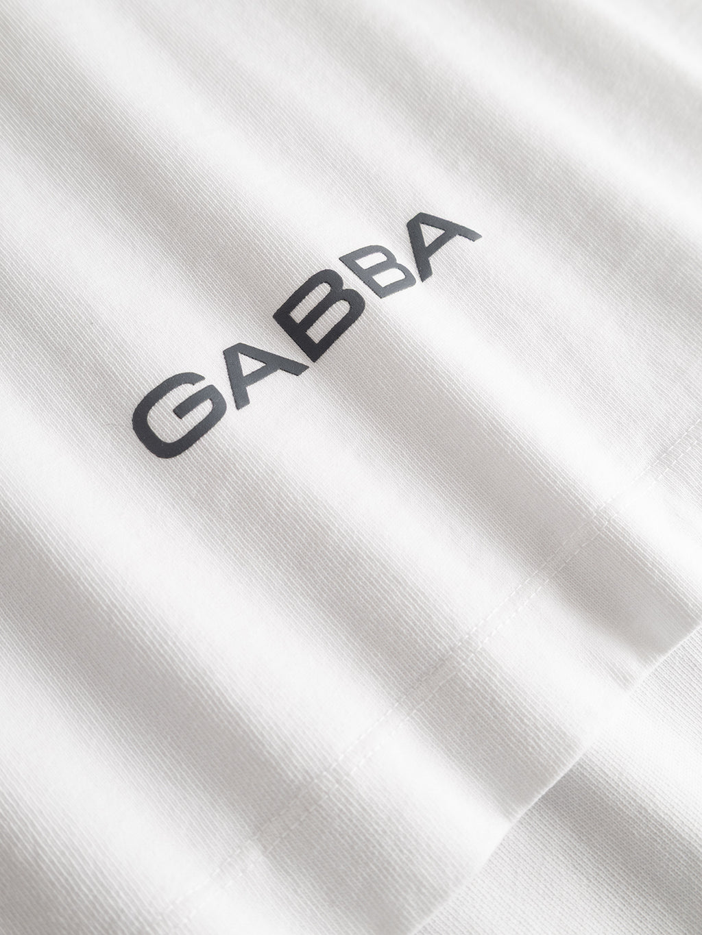 Close-up of the Gabba GABlegin Wix Chap Boxy Hour SS T-Shirt in white, featuring heavyweight, slightly ribbed cotton and bold black 