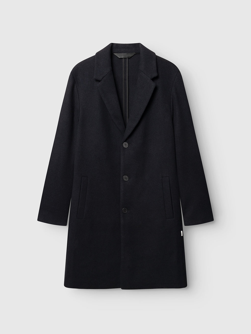 Introducing the GABleeds Plain Coat - Navy by Gabba: a knee-length, navy wool-blend overcoat featuring a notched collar, three front buttons, and two side pockets, displayed against a light gray background—an essential, timeless piece of outerwear for everyday use.