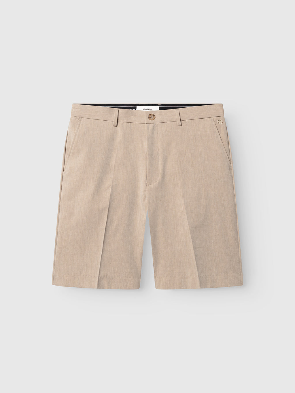 The Gabba GABjoli Tailor Dressy Shorts in sand feature a button and zip closure, side pockets, and belt loops, displayed on a plain light gray background.