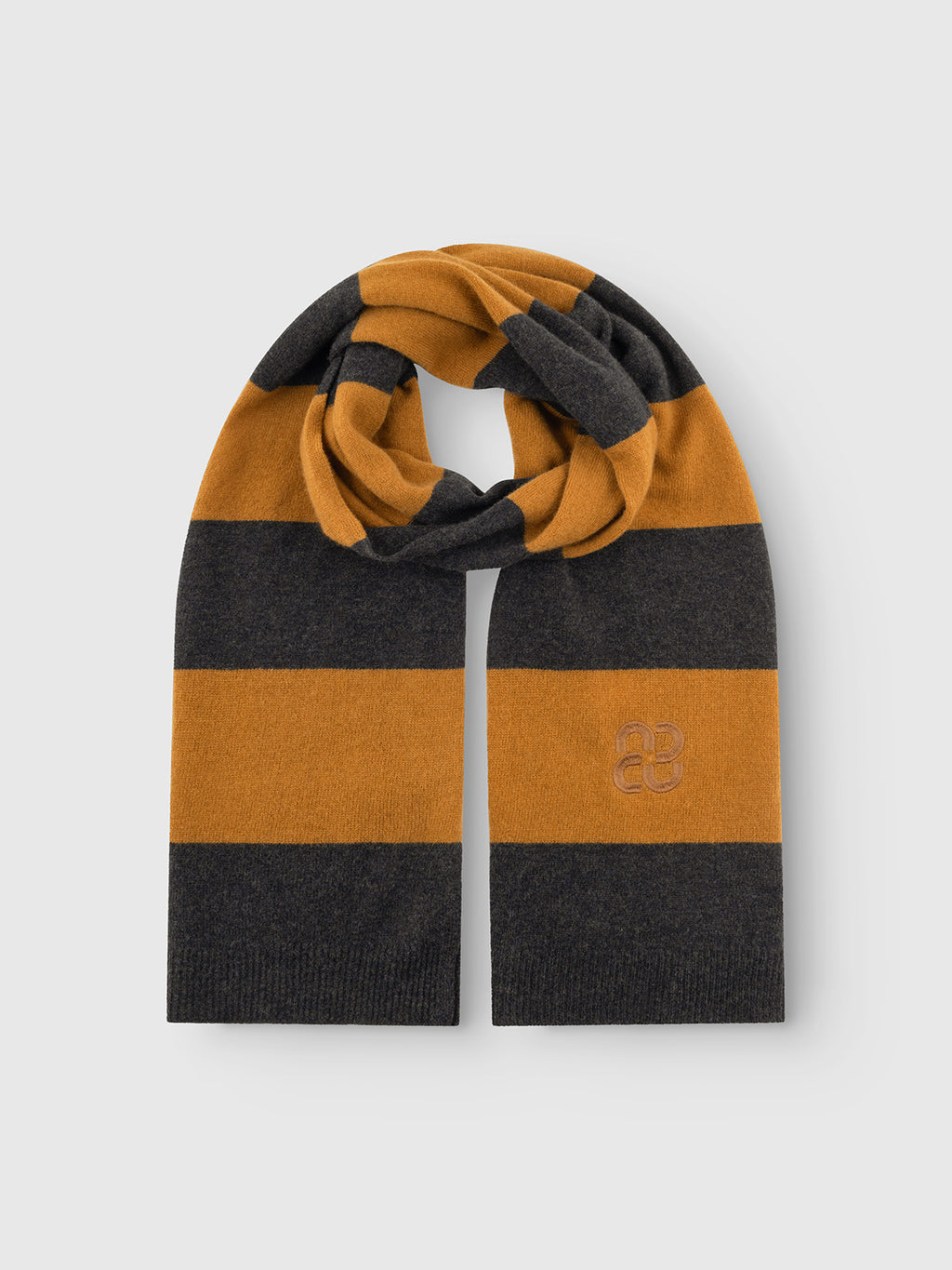 The Gabba GABwest Aico Scarf - Yellow Stripes features wide horizontal stripes in mustard yellow and dark gray and is crafted from knitted merino wool. Neatly folded with an embroidered logo on one end, it is displayed on a plain light gray background—making it an ideal winter accessory.
