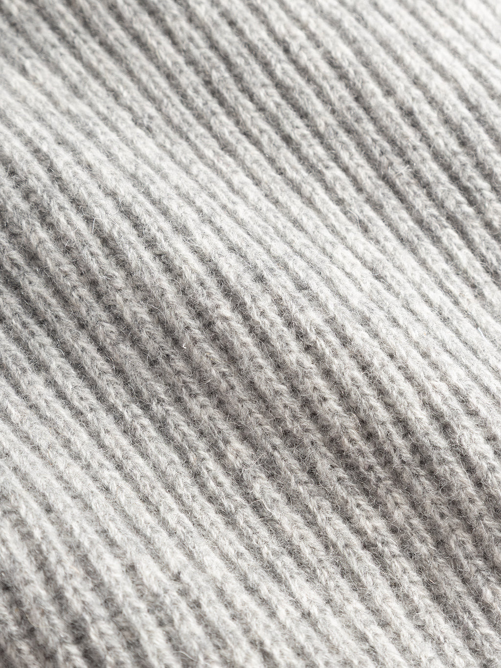 Close-up of the GABeast Flash Scarf in Grey Mel from Gabba, highlighting the soft, textured surface of its gray ribbed knit fabric and the neat parallel lines created by the knitting pattern—perfect details for this cozy winter accessory.