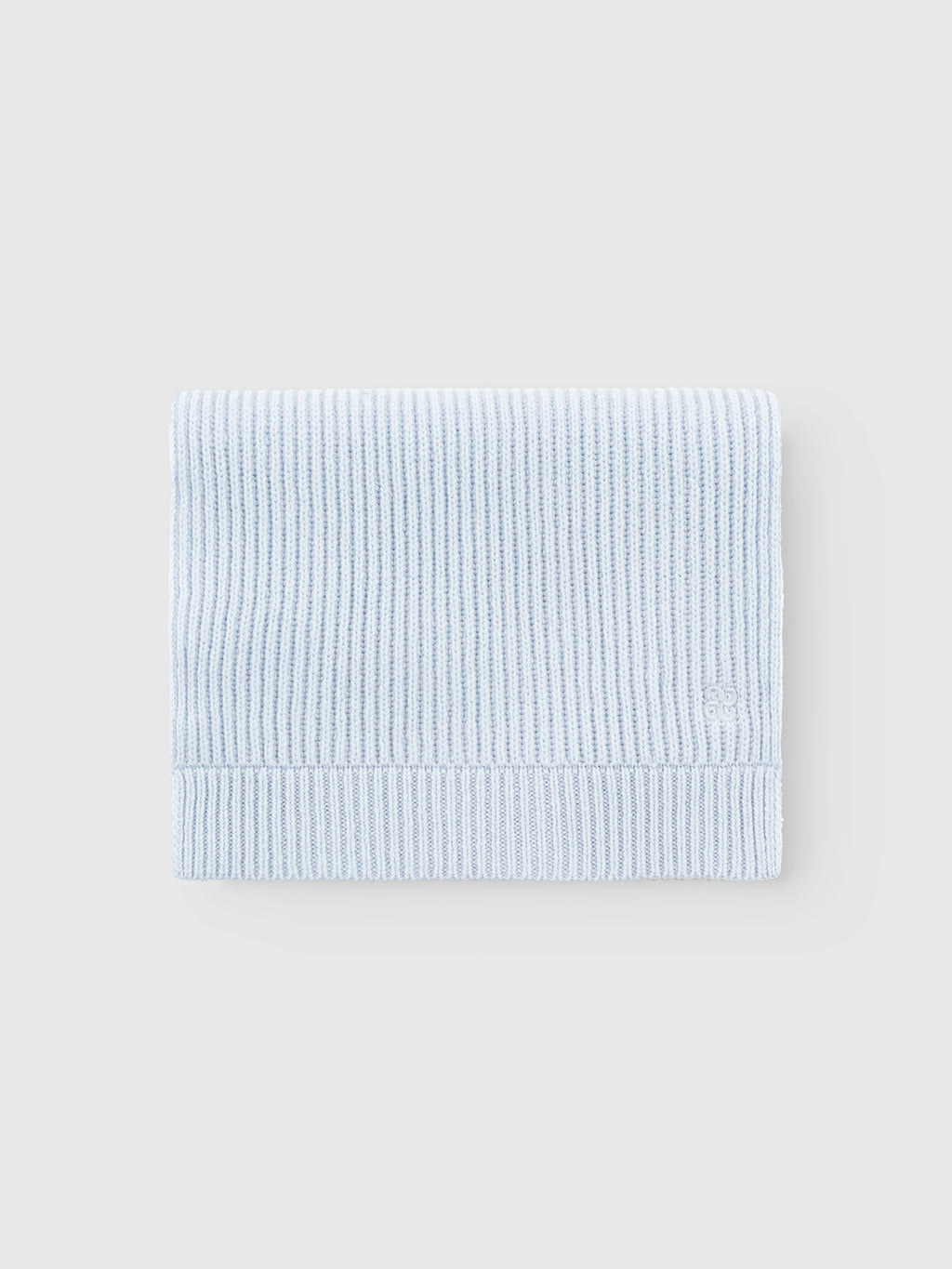 The Gabba GABeast Flash Scarf in Dusty Blue, featuring a rib-knit design, is neatly folded and displayed on a plain light grey background, making it a stylish winter accessory.