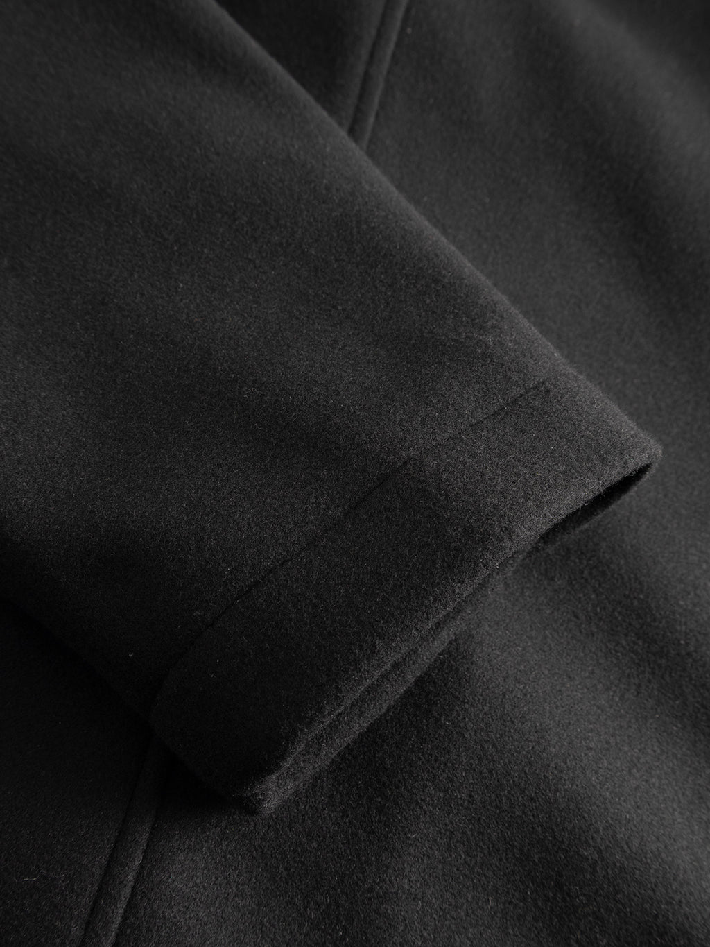 Close-up of a sleeve on the GABmatheo Plain Bomber Jacket in black by Gabba, highlighting the texture of the fabric and intricate seam details—ideal for those who value refined, casual outerwear.